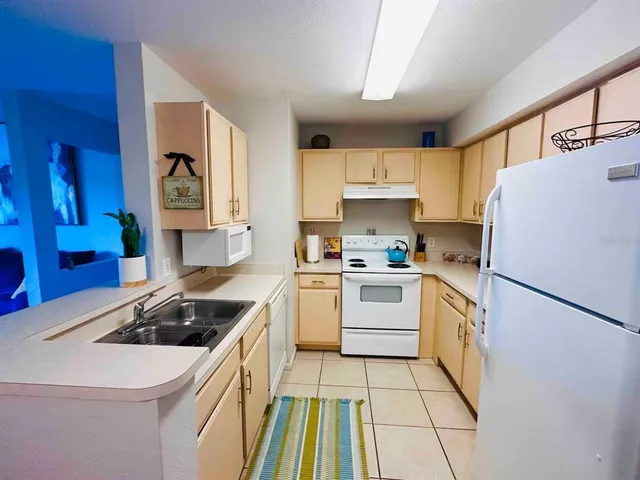 a kitchen with a white stove top oven and refrigerator