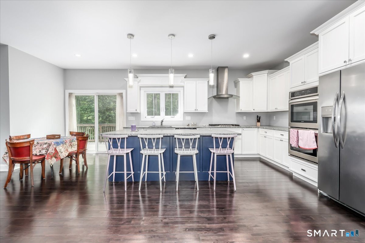 127 Putnam Park Road Bethel, CT 06801 - Photo 3 of 35 a kitchen with stainless steel appliances granite countertop a dining table chairs refrigerator and sink