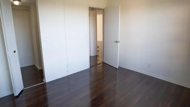 an empty room with wooden floor and closet