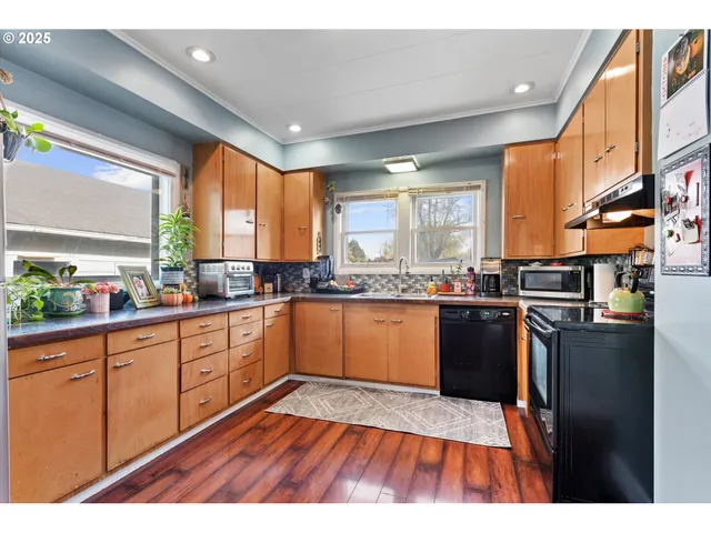 a kitchen with stainless steel appliances granite countertop a sink a stove and wooden cabinets
