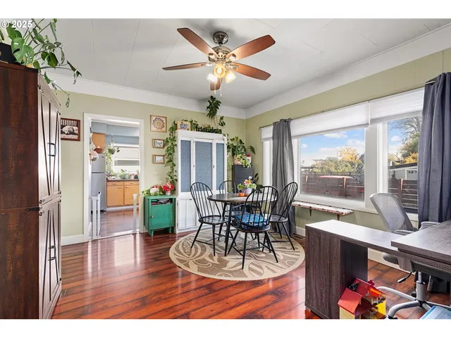 a dining room with wooden floor a chandelier fan a glass table and chairs