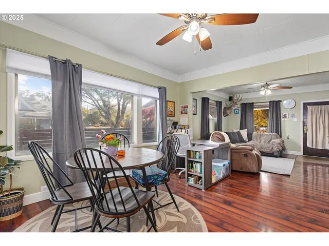 a dining room with furniture a chandelier and wooden floor