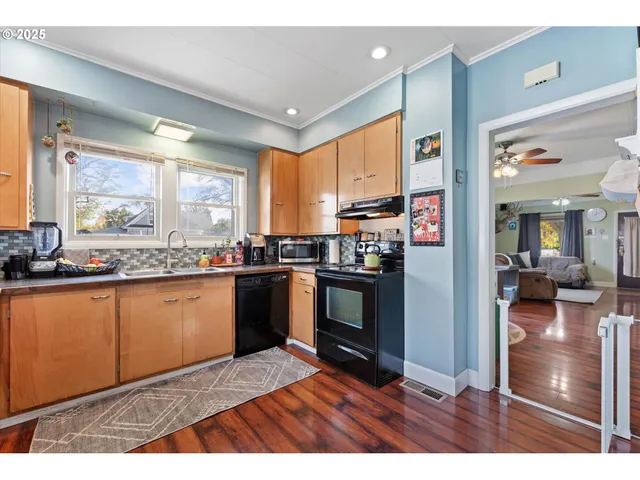 a kitchen with granite countertop a stove cabinets and living room