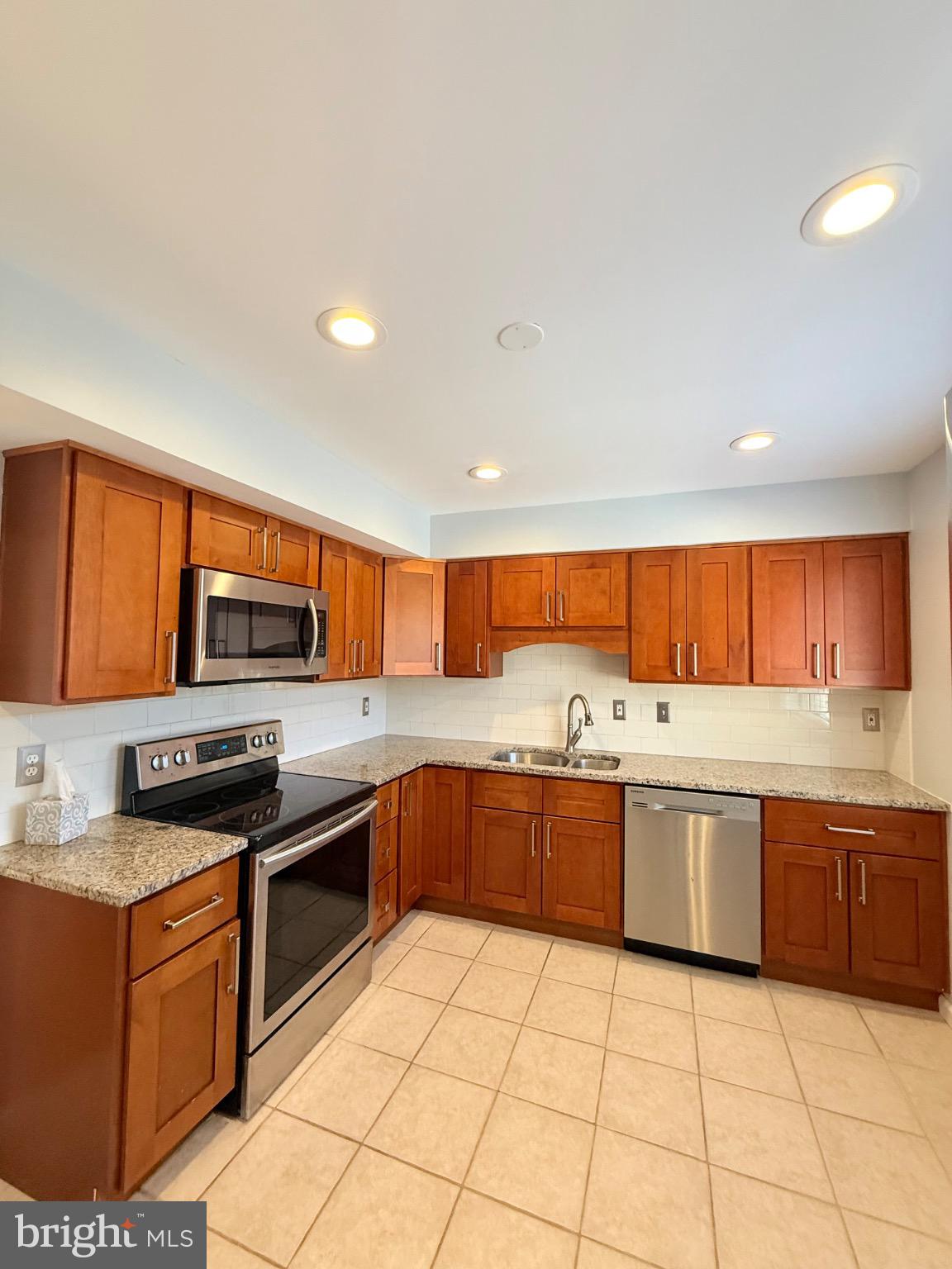 7250 Lasting Way Columbia, MD 21045 - Photo 3 of 39 Modern kitchen with rich wood cabinetry.