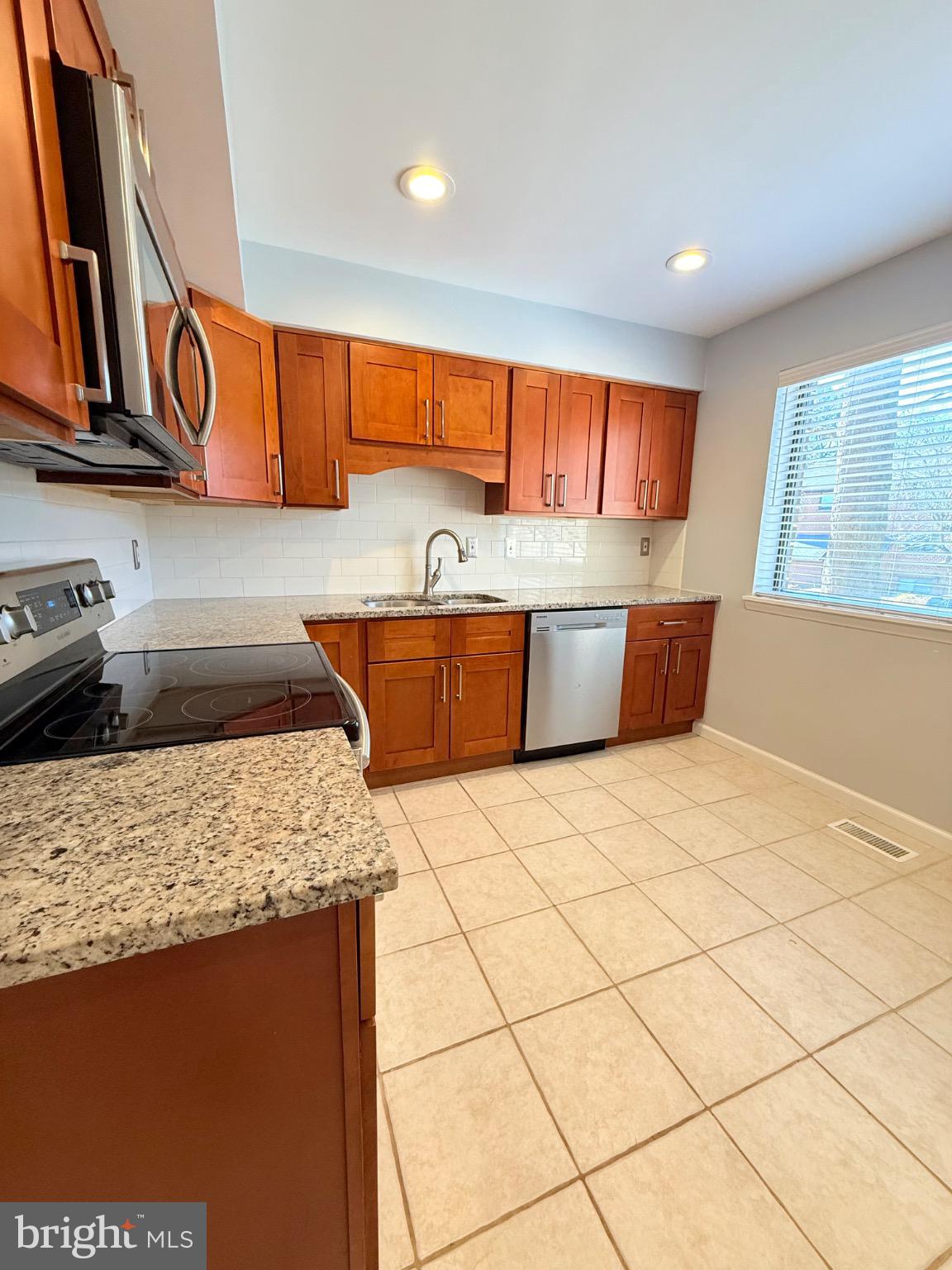 7250 Lasting Way Columbia, MD 21045 - Photo 6 of 39 Modern kitchen with warm wood cabinetry.