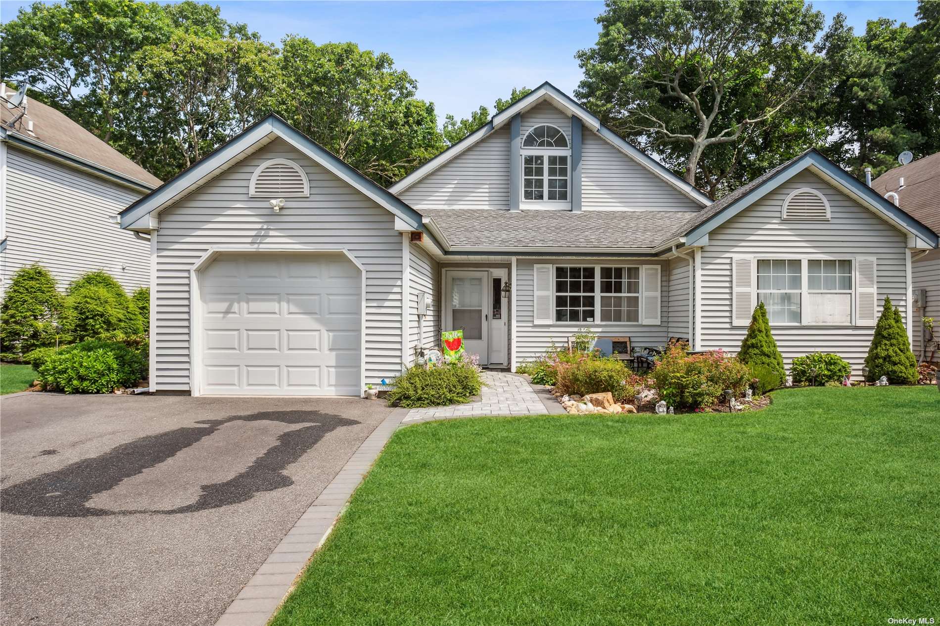 a front view of a house with a garden and yard