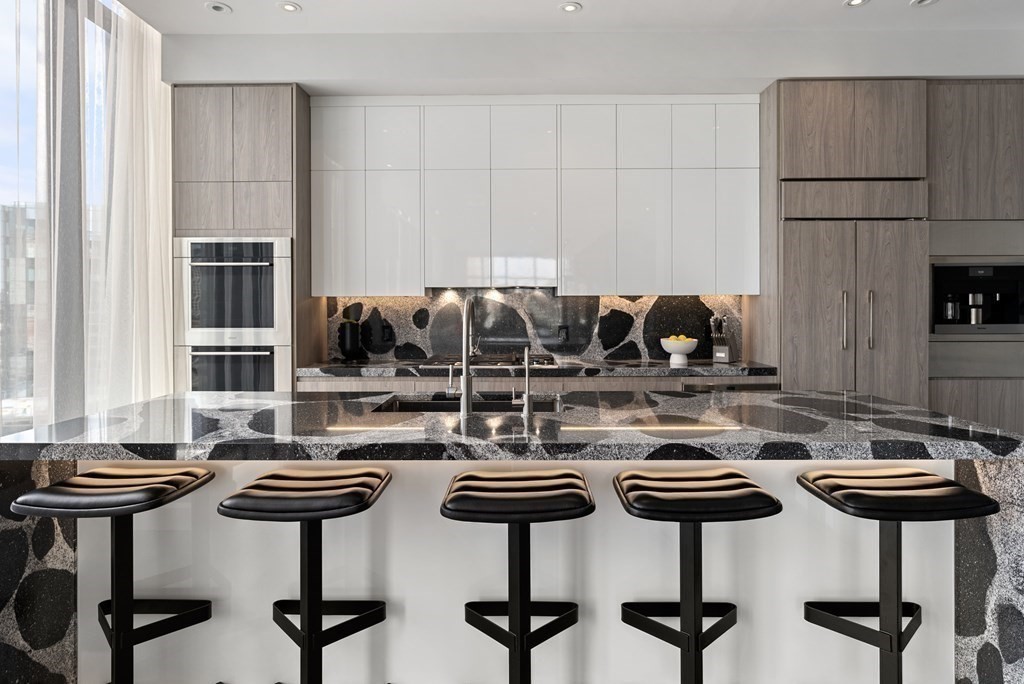 140 Shawmut Avenue, Unit 8A Boston, MA 02118 - Photo 12 of 29 a kitchen with a kitchen island a stove a table and chairs in it