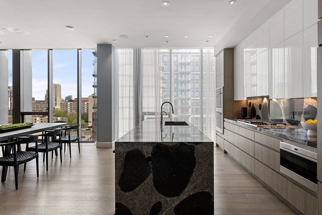 140 Shawmut Avenue, Unit 8A Boston, MA 02118 - Photo 14 of 29 a kitchen with stainless steel appliances granite countertop a stove top oven a sink a dining table and chairs