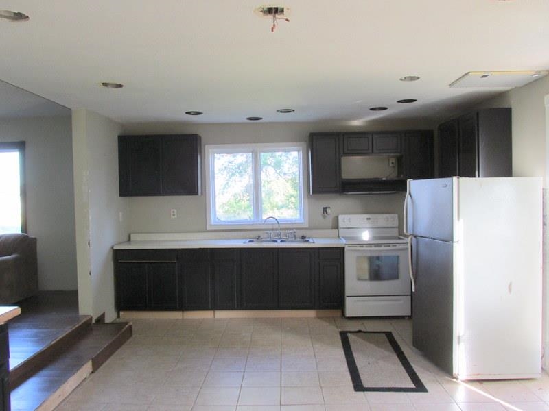 15917 West Harper Road Forreston, IL 61030 - Photo 8 of 38 a kitchen with granite countertop a refrigerator and a stove top oven
