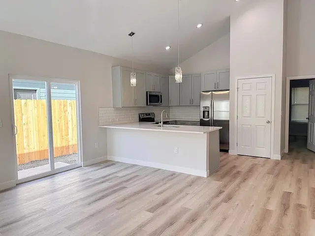 a view of kitchen with wooden floor and electronic appliances