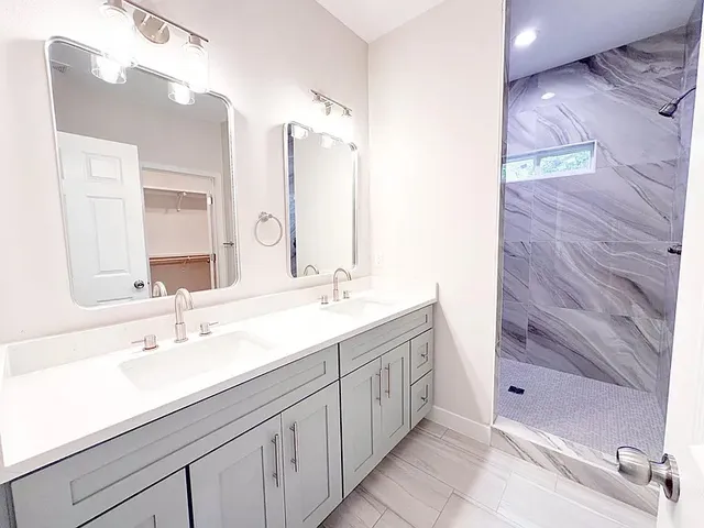 a bathroom with a double vanity sink mirror and