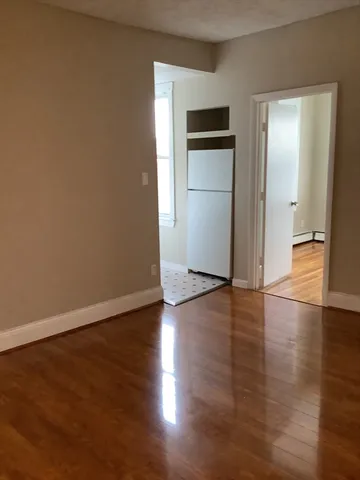 an empty room with wooden floor and closet