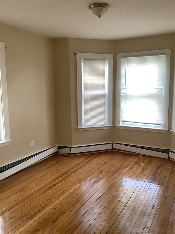 61 Vine Street, Unit 35 Lynn, MA 01905 - Photo 2 of 11 an empty room with wooden floor and windows