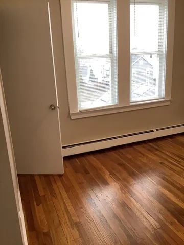 a view of a room with wooden floor and windows