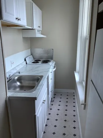 a kitchen with a sink a stove and cabinets