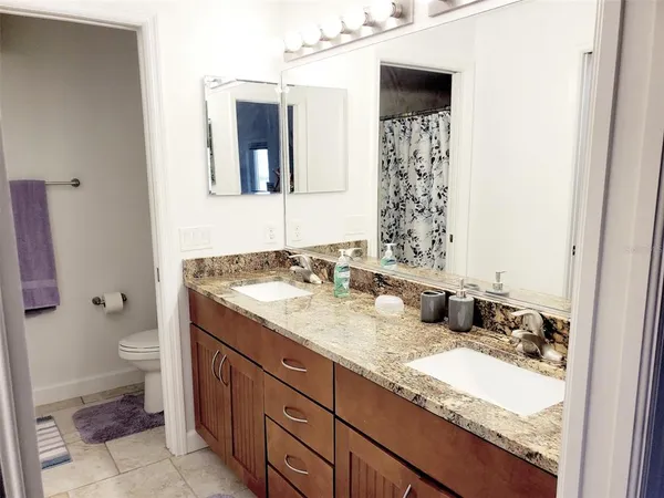 a bathroom with a granite countertop sink toilet and shower