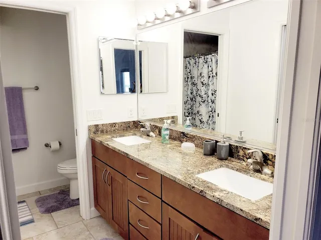 a bathroom with a granite countertop sink toilet and shower
