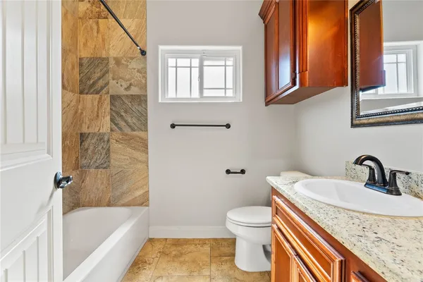 a bathroom with a granite countertop sink toilet and shower