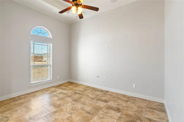 an empty room with a window and a fan