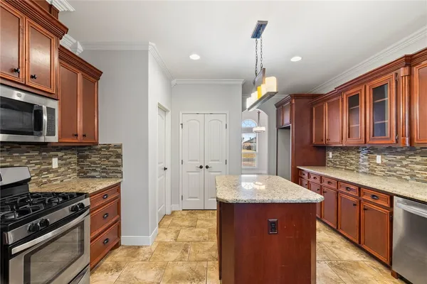 a kitchen with stainless steel appliances granite countertop a sink stove and refrigerator