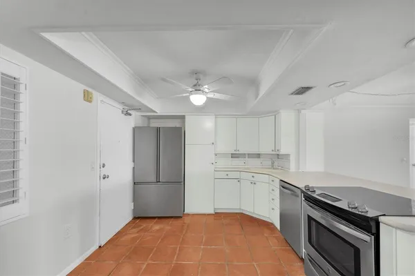 a kitchen with white cabinets and stainless steel appliances