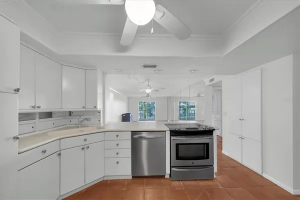 a kitchen with stainless steel appliances granite countertop a stove a sink and white cabinets