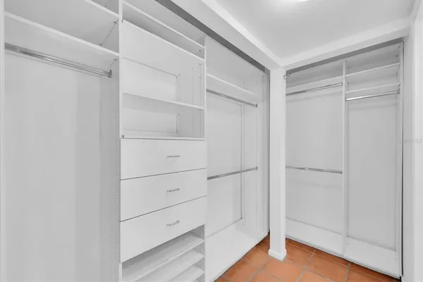 a view of walk in closet with empty racks