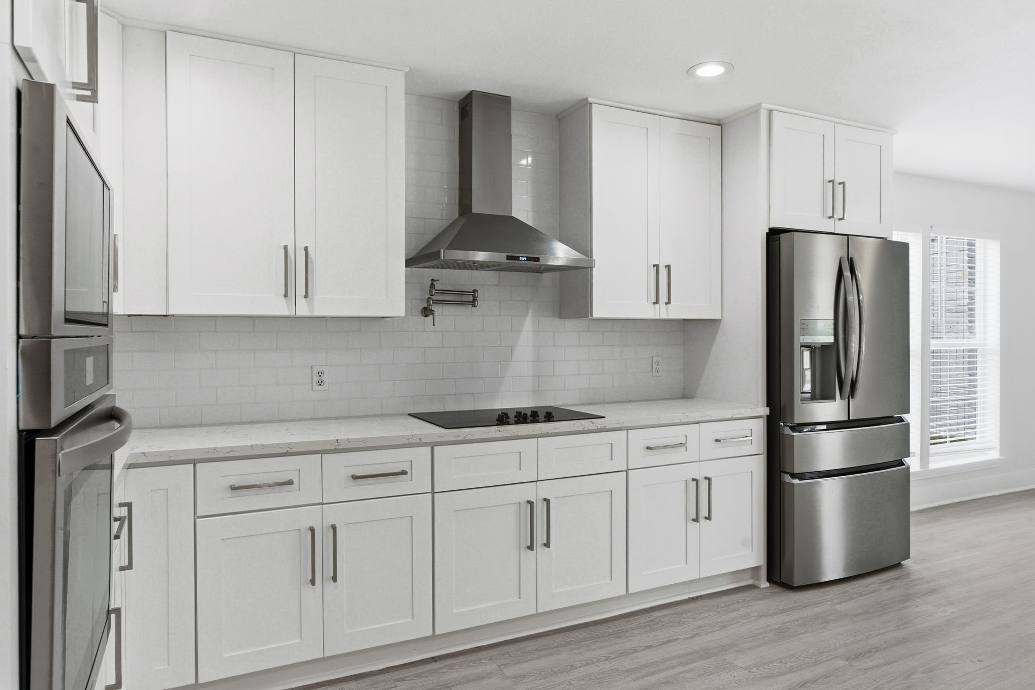 13811 Menasco Court Houston, TX 77077 - Photo 18 of 50 From this angle of the kitchen you can see there is an electric cooktop with vent hood and Frigidaire stainless steel refrigerator.