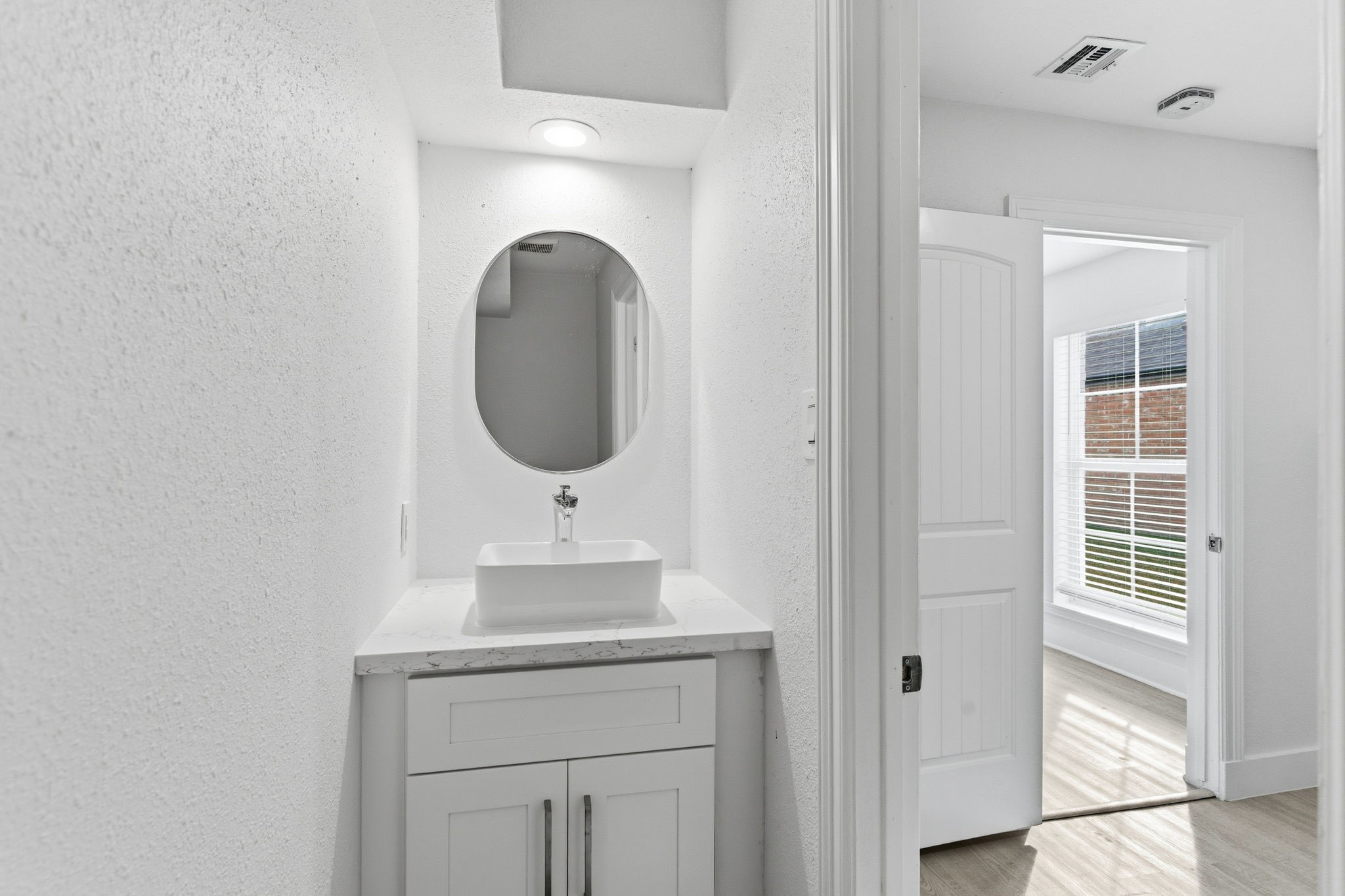 13811 Menasco Court Houston, TX 77077 - Photo 24 of 50 The half bathroom is located in the utility room with an updated vanity, recent sink, mirror and recent toilet (2025).