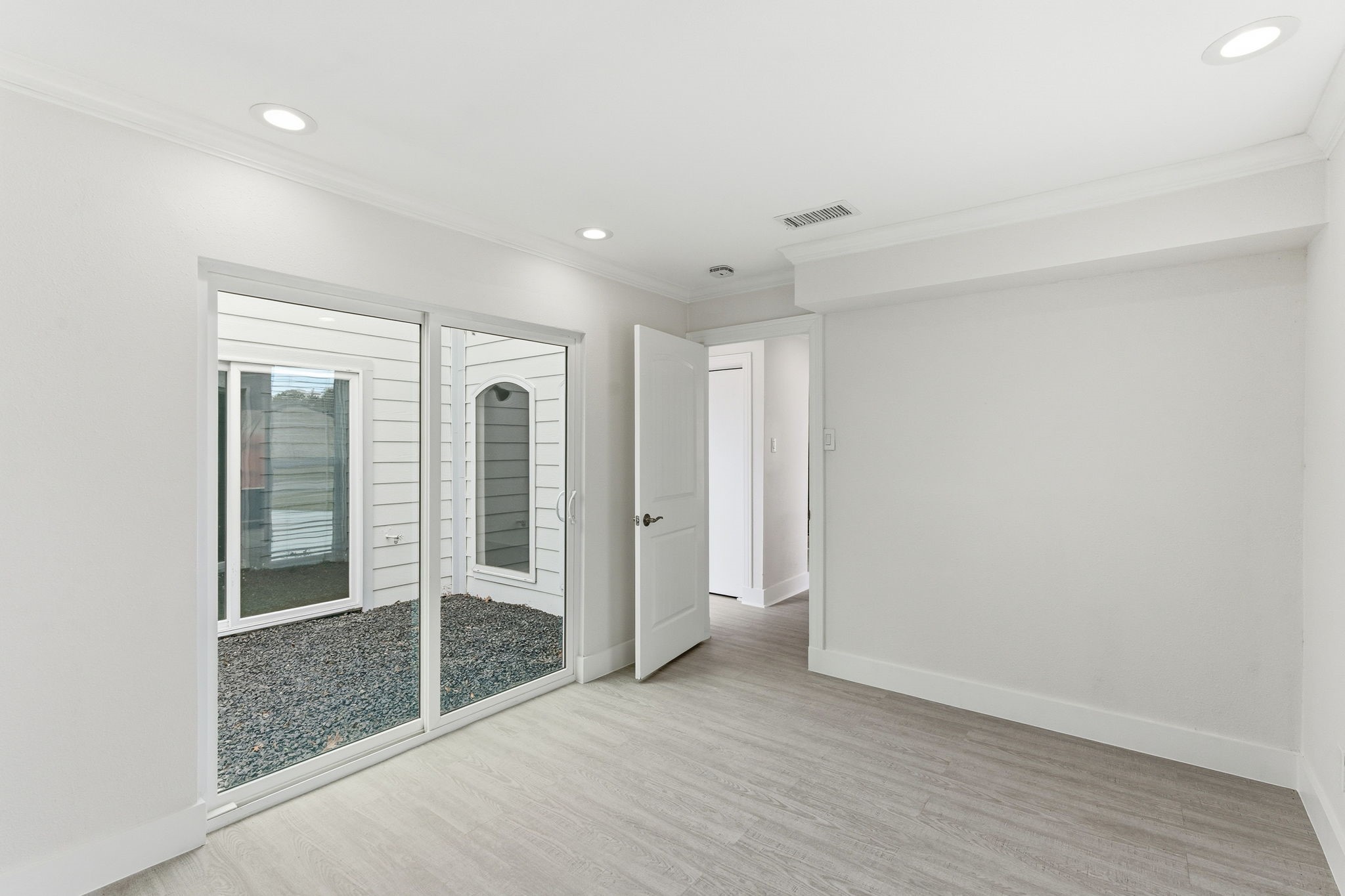 13811 Menasco Court Houston, TX 77077 - Photo 26 of 50 This extra bedroom is located to the left when you first walk through the front doors. It features recessed lighting, crown molding, nice size closet and double pane sliding glass door to access the backyard.