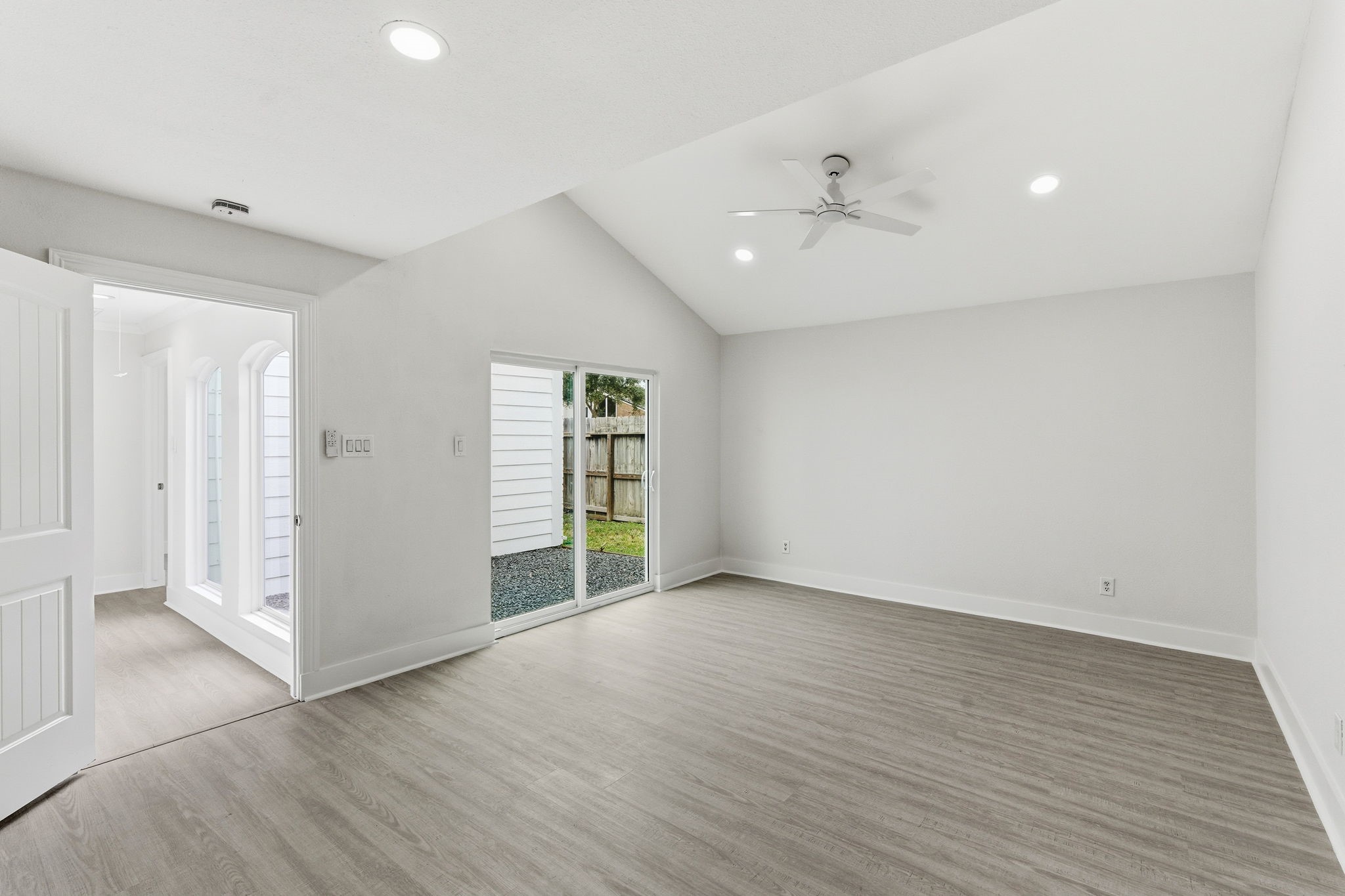 13811 Menasco Court Houston, TX 77077 - Photo 28 of 50 The primary bedroom showcases luxury vinyl plank floors, high ceilings, LED recessed lighting, a ceiling fan and double pane sliding glass door to access the backyard.