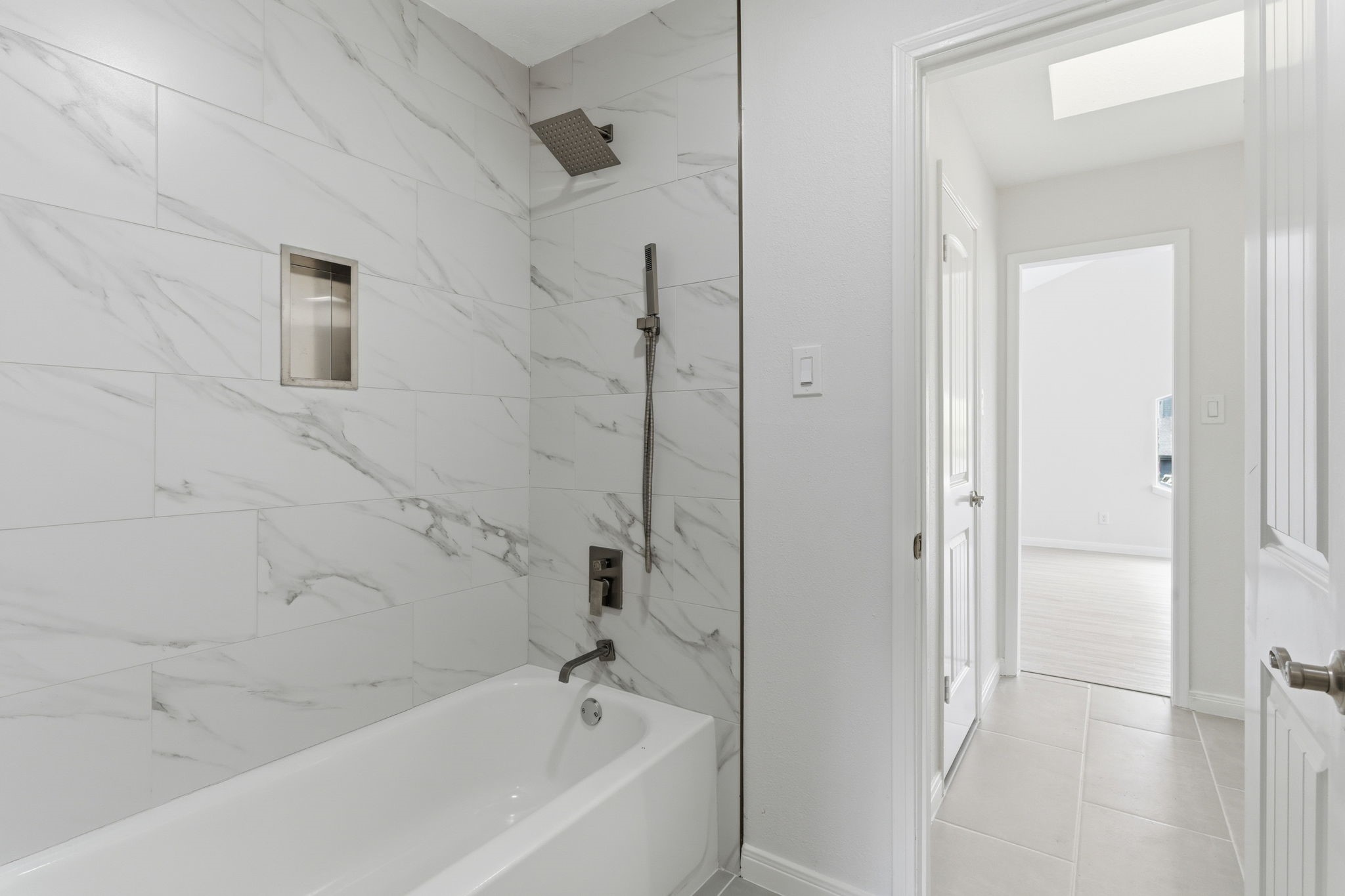 13811 Menasco Court Houston, TX 77077 - Photo 36 of 50 The tub+shower duo in the second full bathroom upstairs has been updated with recent tile surround.