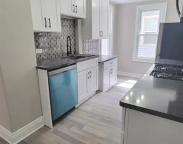 a kitchen with stainless steel appliances granite countertop a sink stove and cabinets
