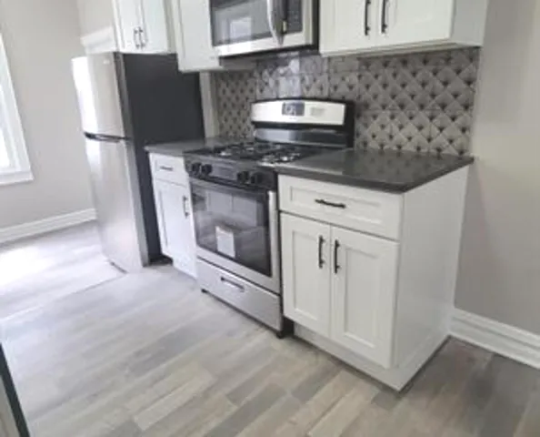 a kitchen with stainless steel appliances a stove a microwave and a refrigerator
