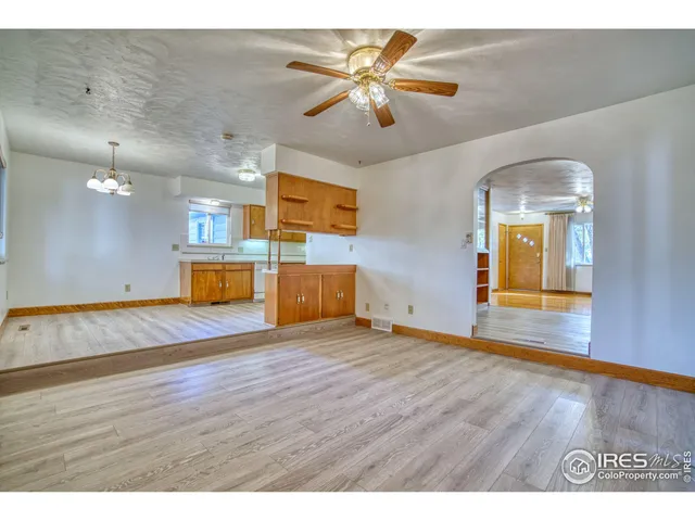 a view of a room with wooden floor and a ceiling fan