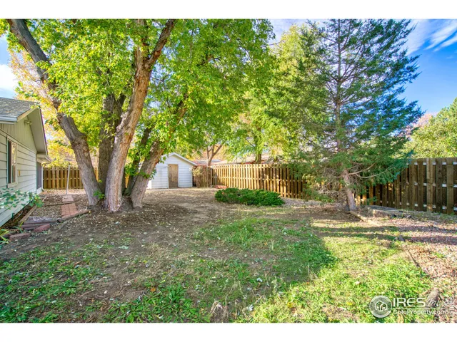 a view of a yard with wooden fence