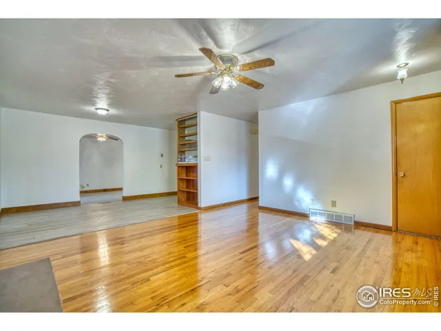 a view of an empty room with wooden floor