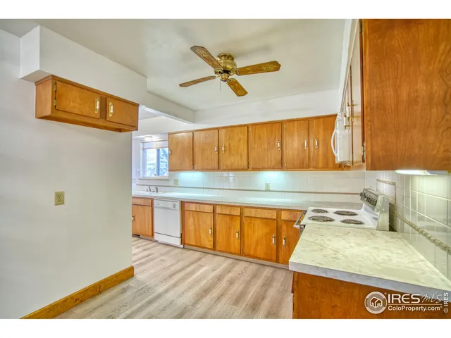 a kitchen with stainless steel appliances granite countertop a sink and a cabinets with wooden floor