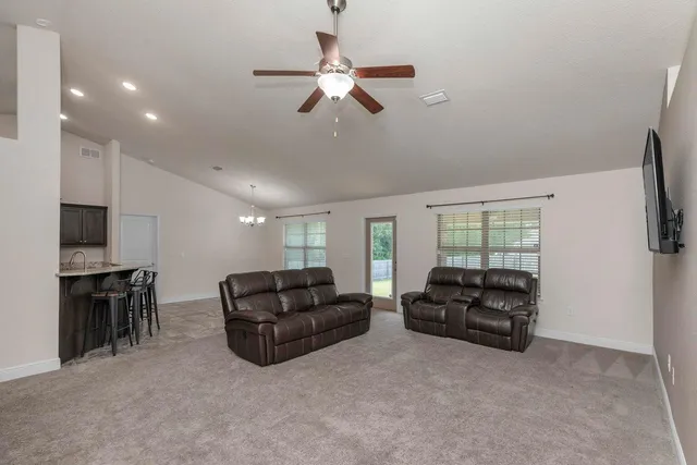 a living room with furniture ceiling fan and a window
