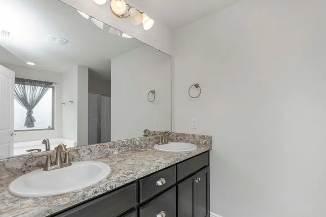 a bathroom with a granite countertop sink a mirror and a