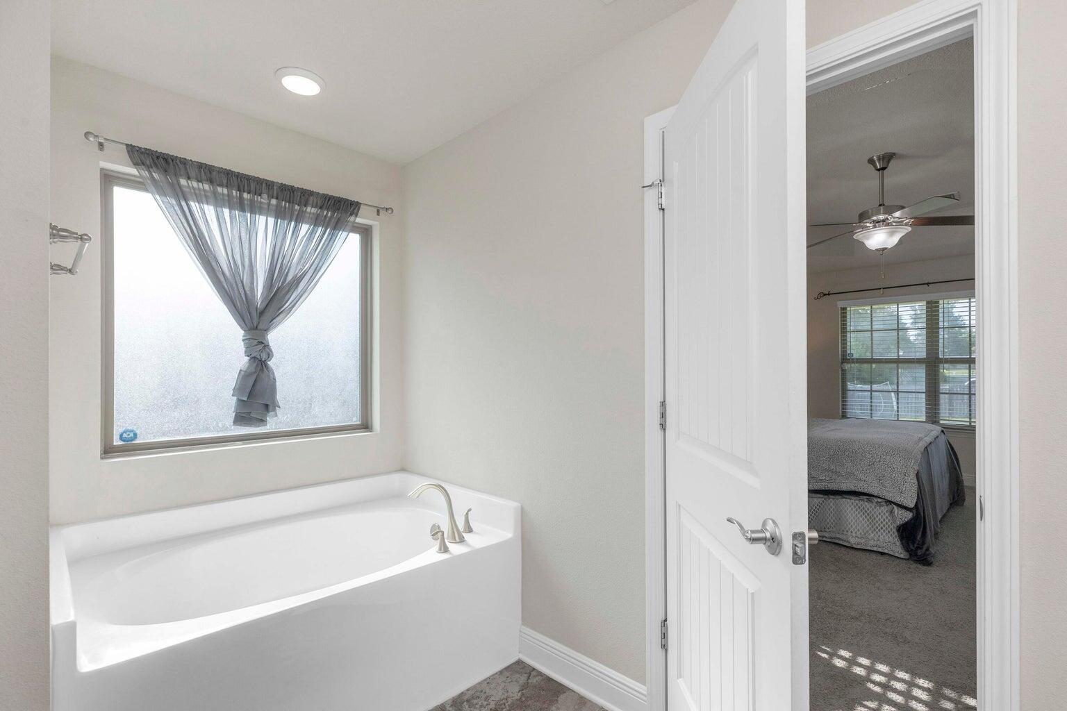 2365 Genevieve Way Crestview, FL 32536 - Photo 22 of 33 a bathroom with a tub a sink and a window