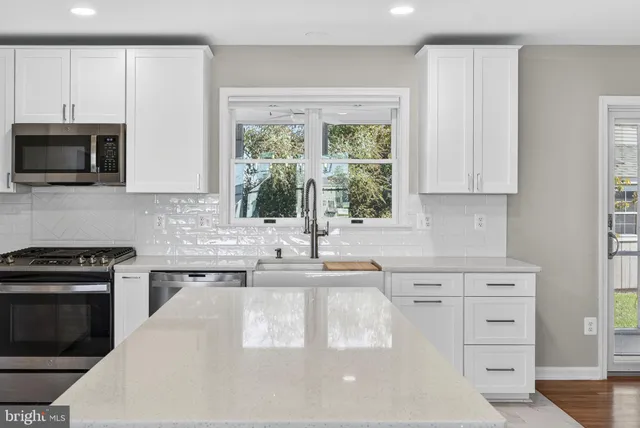 a kitchen with granite countertop a stove sink and microwave