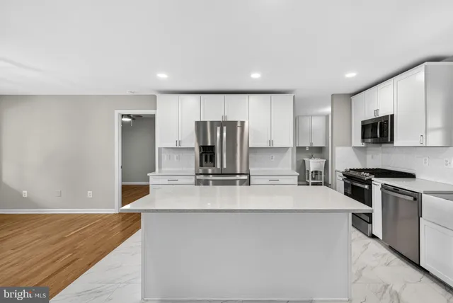 a kitchen with stainless steel appliances granite countertop a sink a stove a refrigerator a granite counter tops and a oven