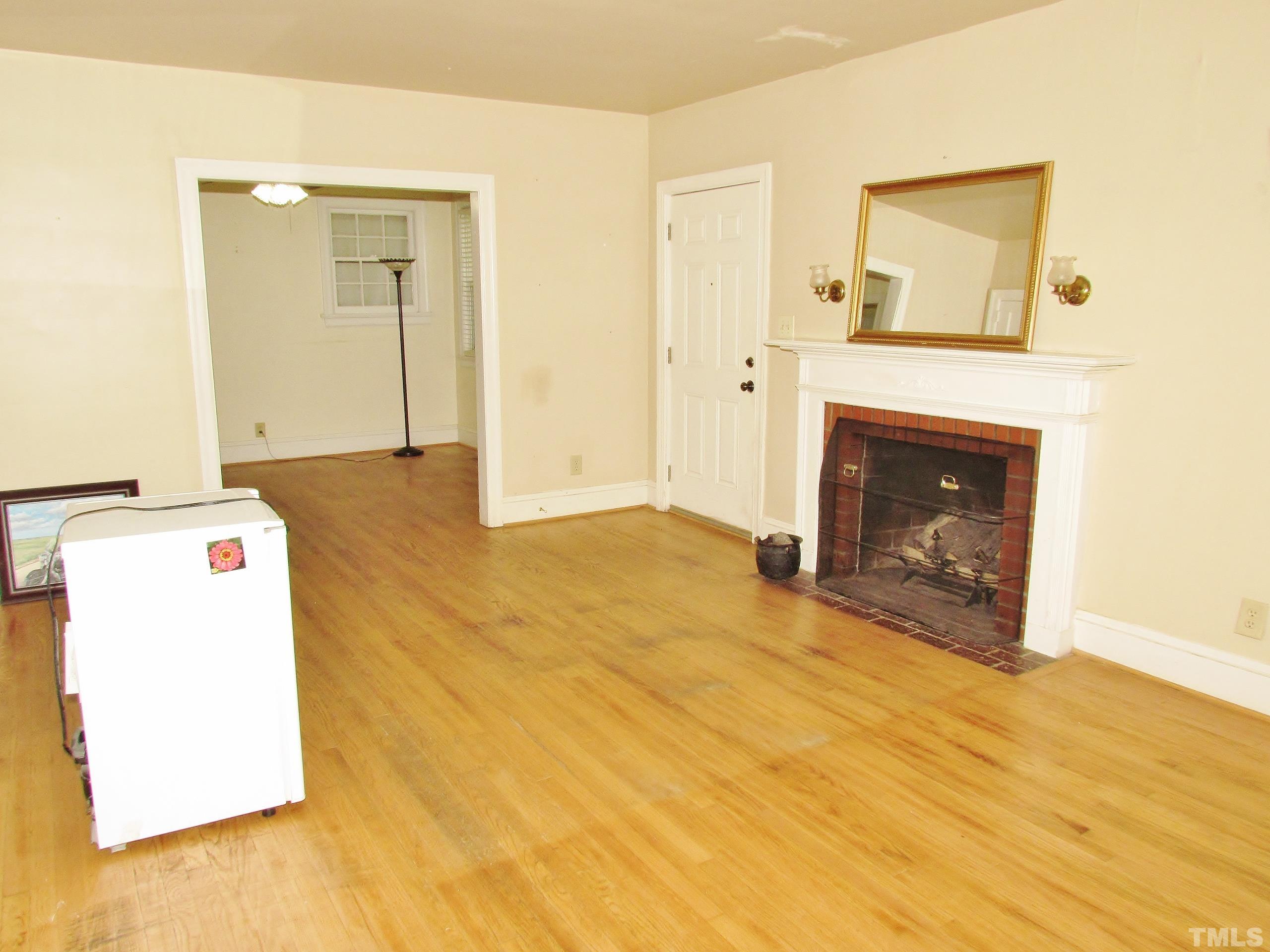 1422 Chester Road Raleigh, NC 27608 - Photo 7 of 47 a view of empty room with a fireplace and wooden floor