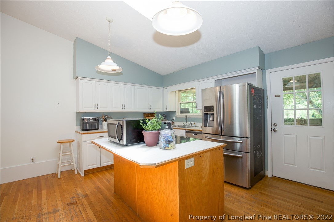327 Scott Road Cameron, NC 28326 - Photo 13 of 48 a kitchen with stainless steel appliances granite countertop a refrigerator a sink dishwasher a stove with wooden cabinets and floor
