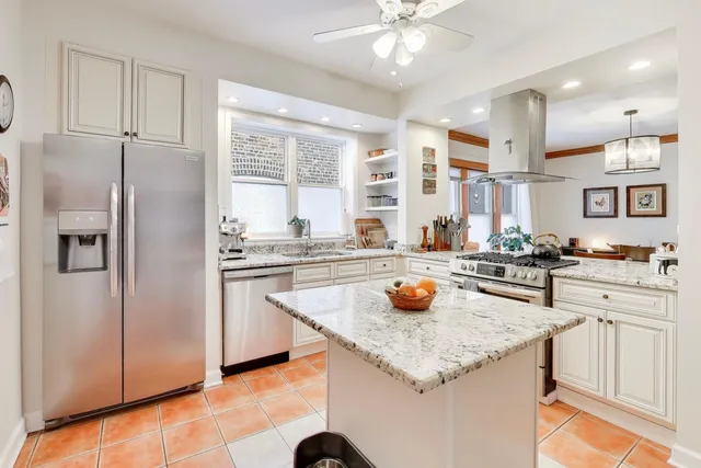 a kitchen with stainless steel appliances granite countertop a sink and a refrigerator