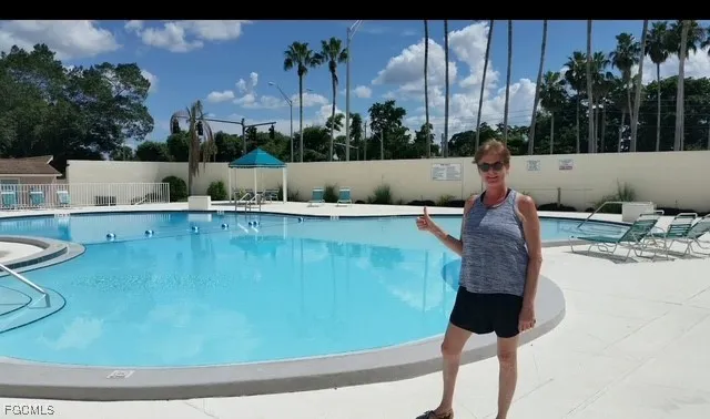 a view of a swimming pool with a yard and seating space
