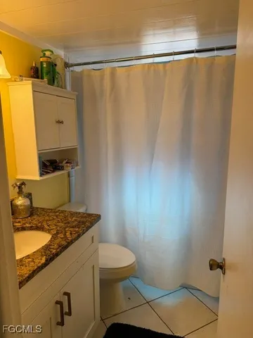 a bathroom with a granite countertop sink toilet and a mirror