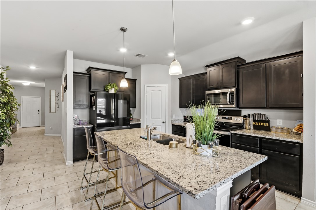 2009 Chief Street Bryan, TX 77807 - Photo 8 of 27 a kitchen with stainless steel appliances kitchen island granite countertop a kitchen island and chairs in it