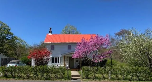 a front view of a house with a yard and tree s